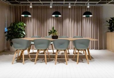 Contemporary meeting room with grey bucket chairs and a large wooden conference table.