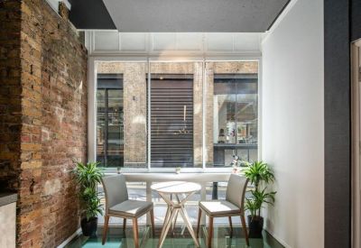 Modern breakout area featuring two chairs and a round table on a unique glass floor panel.