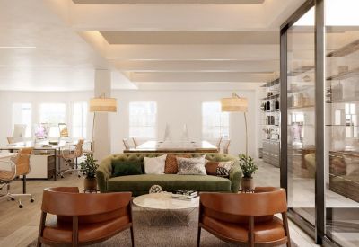 Spacious lounge area with an olive green sofa, leather armchairs, and floor lamps.