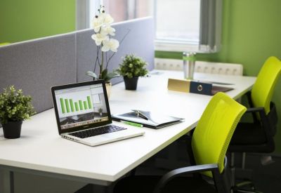 Workspace with a laptop and bright lime-green office chairs.