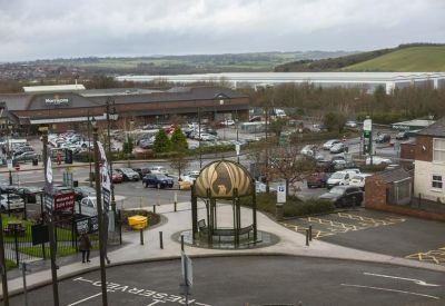 Elevated view overlooking a town center with a central gazebo and commercial buildings.