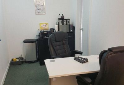 Workstation area with desks, office chairs, and a coffee preparation corner.