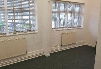 Bright, empty private office suite with white walls and green carpeting.