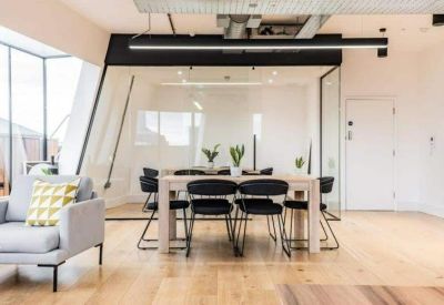 Meeting room with a long wooden table enclosed in a glass partition.
