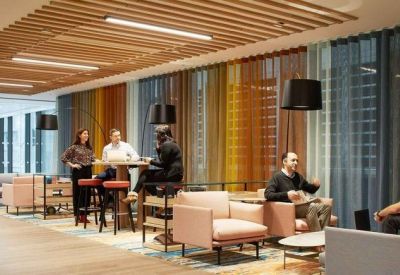 Bright communal lounge with colorful curtains and plush armchairs.