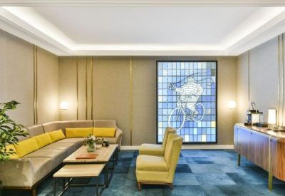 Modern lounge area with velvet seating and a large backlit stained-glass window.