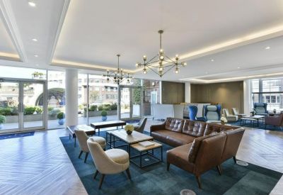 Spacious reception lounge with mid-century modern furniture and large glass doors.