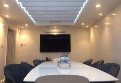 Bright boardroom with a white conference table, blue velvet chairs, and integrated ceiling lighting.