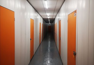 Long corridor lined with several orange storage unit doors.