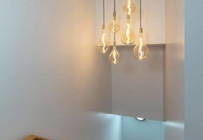 Bright stairwell featuring a unique cluster of decorative hanging light bulbs.