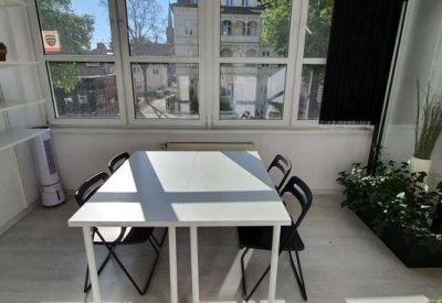 Private office space with a white desk and large windows overlooking a courtyard.