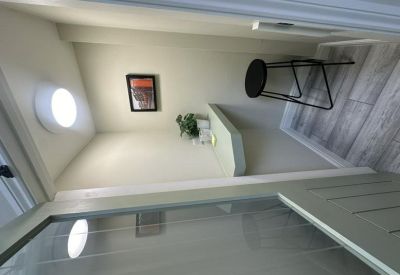 Built-in wall desk nook with a circular light and black bar stool.