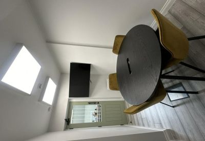 Circular black meeting table with three yellow velvet chairs.