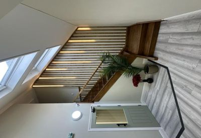 Modern wooden staircase with integrated lighting strips and decorative plants.