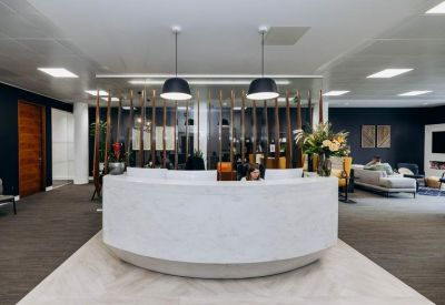Curved marble reception desk in a spacious lobby with blue feature walls.
