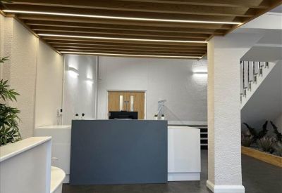Reception desk area with a dark grey counter and modern overhead wood slats.