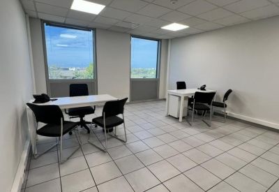 Spacious office suite with two white desks and large windows overlooking the city.