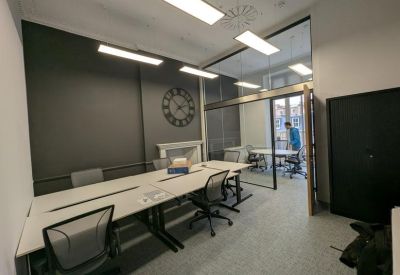 Long workstation desks with ergonomic chairs in a modern office suite.