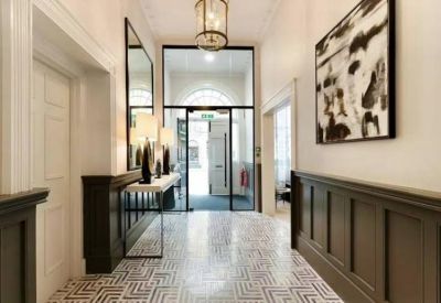 Bright hallway with patterned tile flooring and decorative wall paneling.
