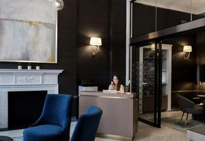 Elegant reception area at 93 Gloucester Place featuring a marble fireplace and blue velvet armchairs.