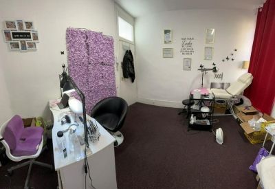 Bright beauty treatment room with a purple feature wall and professional equipment.