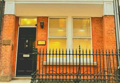 Exterior view of the brick facade and black entrance door at 97 Mortimer Street.