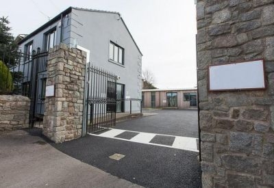 Gated entrance to the stone and grey facade of Abbey Yard Studios.