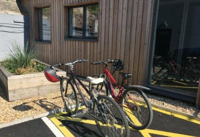 On-site bicycle parking area with yellow markings and raised wooden planters.