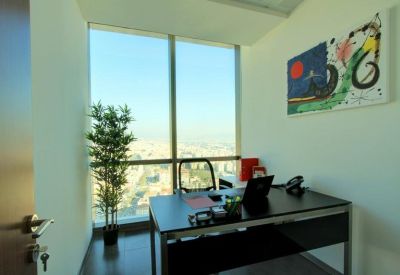 Private office featuring a black desk, potted plant, and expansive window view.