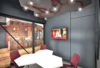 Modern meeting room with hexagonal tables, red chairs, and a creative ceiling light installation.