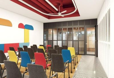 Colorful seminar room with vibrant chairs, geometric wall art, and a decorative red ceiling.