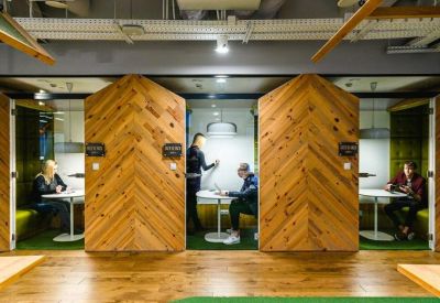 Private wooden work booths with herringbone patterns and individual lighting.
