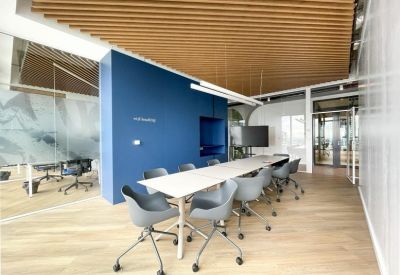 Sleek conference room with grey chairs and a large wall-mounted screen.
