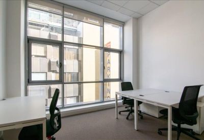 Private office suite with white desks, black ergonomic chairs and large windows.