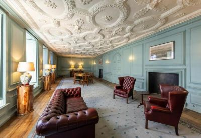 Traditional reception lounge with a leather Chesterfield sofa and classical wall moldings.