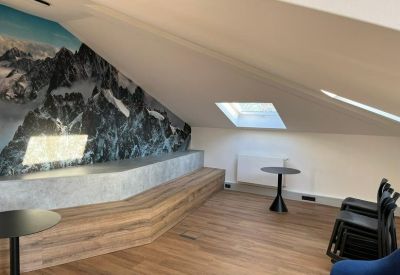 Breakout area with wooden tiered seating and a mountain landscape mural.