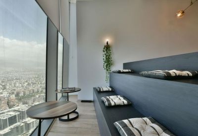 Modern terraced seating area with floor cushions and expansive city views.