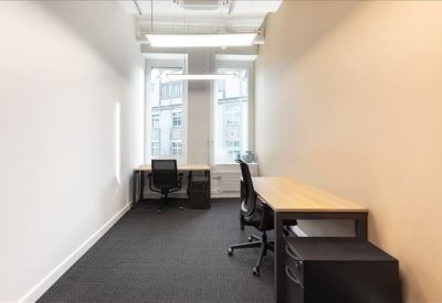 Narrow two-person private office with white walls and dual workstations.