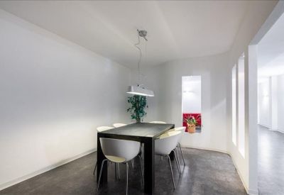 Breakout area featuring a dark wooden table, white chairs, and a small green plant.