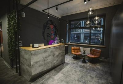 Modern reception area with a wood-fronted desk and artistic wall mural.