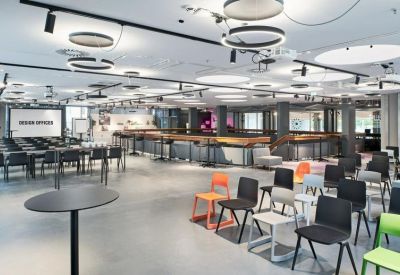 Spacious communal event space with diverse seating options and modern circular lighting.