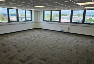 Corner office space featuring large black-framed windows and modern wall-mounted heaters.
