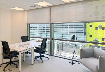 Private office suite with a white desk and large windows overlooking the city.