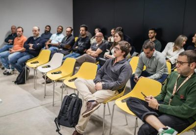 Group of professionals seated in yellow and white chairs during a workshop or presentation.