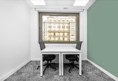 Private two-person office with a green feature wall and a large window.