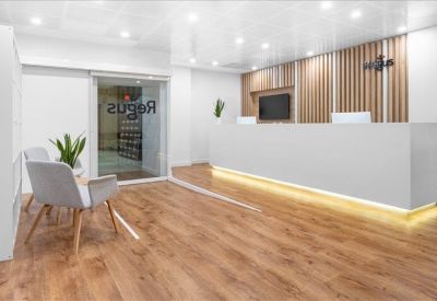 Sleek reception area with a long white desk, wooden floors, and slatted wood wall.