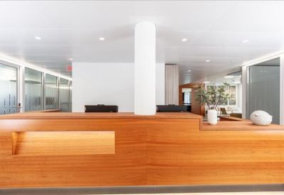 Clean, professional reception desk featuring warm wood tones and bright white lighting.