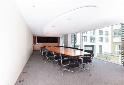 Sleek conference room with a long wooden table and large windows overlooking the city.