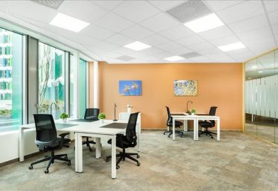 Bright four-person office suite with an orange feature wall and large windows.