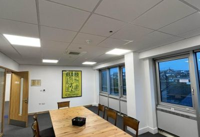 Professional meeting room featuring a long wooden table and large windows with city views.